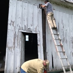 Two LCHPS volunteers hard at work on the east doors of the barn.